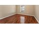A bedroom features wood flooring and a window at 5809 War Admiral Dr, Wesley Chapel, FL 33544