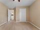 Bedroom featuring neutral walls, carpet flooring, closet with double doors and view of kitchen through doorway at 5809 War Admiral Dr, Wesley Chapel, FL 33544