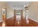 Open-concept living room featuring hardwood floors, a modern light fixture, and access to the backyard at 5809 War Admiral Dr, Wesley Chapel, FL 33544