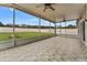 Enclosed patio with ceiling fan and view of spacious backyard with fire pit and white fencing at 5809 War Admiral Dr, Wesley Chapel, FL 33544