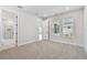 Bright bedroom with carpeted floors, white walls, and windows with a view to the exterior at 687 Allora Ave, Nokomis, FL 34275