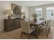 Elegant dining room with a rustic wood table, upholstered chairs, sideboard, and decorative lighting at 687 Allora Ave, Nokomis, FL 34275