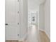 Bright hallway featuring new laminate flooring and neutral paint, leading to various rooms in the home at 687 Allora Ave, Nokomis, FL 34275