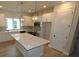 Modern kitchen featuring white cabinets, a large island with quartz countertops, and stylish pendant lighting at 687 Allora Ave, Nokomis, FL 34275