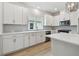 Modern kitchen featuring stainless steel appliances, quartz countertops, white cabinets, and gray backsplash at 687 Allora Ave, Nokomis, FL 34275