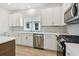 Bright kitchen featuring stainless steel appliances, white cabinetry, and a light gray backsplash at 687 Allora Ave, Nokomis, FL 34275