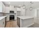 Well-equipped kitchen showcasing stainless appliances, white cabinets, a microwave, and stylish pendant lights over the island at 687 Allora Ave, Nokomis, FL 34275