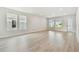 Open living room with plenty of natural light from three large windows, and light colored wood floors at 687 Allora Ave, Nokomis, FL 34275