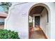 Condo entrance featuring an arched entryway with a brick walkway and attractive landscaping at 3505 Tarpon Woods Blvd # K406, Palm Harbor, FL 34685