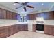 Cozy kitchen features brown cabinets, white countertops, tile floors, and modern appliances at 3505 Tarpon Woods Blvd # K406, Palm Harbor, FL 34685