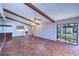 Living room features hardwood floors, vaulted ceilings with wood beams, and a large sliding glass door at 3505 Tarpon Woods Blvd # K406, Palm Harbor, FL 34685