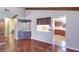 Living room featuring hardwood floors, vaulted ceilings with wood beams, a wet bar, and pass-through kitchen at 3505 Tarpon Woods Blvd # K406, Palm Harbor, FL 34685