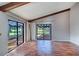 Bright living room featuring hardwood floors, vaulted ceilings with wood beams, and sliding glass doors at 3505 Tarpon Woods Blvd # K406, Palm Harbor, FL 34685