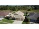 A tranquil view of a single story home with a three-car garage, lush lawn, and pond view at 10025 Cypress Shadow Ave, Tampa, FL 33647
