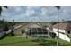 Backyard view of a screened-in pool area with a well-maintained lawn and landscaped garden at 10025 Cypress Shadow Ave, Tampa, FL 33647
