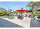 Beautiful pool and patio area featuring mature landscaping, a red umbrella and outdoor seating at 1309 Nokomis S Ave, Venice, FL 34285