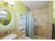 Brightly painted bathroom showcasing a tiled shower, decorative mirror, and updated fixtures at 1309 Nokomis S Ave, Venice, FL 34285