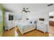Bright bedroom featuring wood floors, a ceiling fan, and a built-in TV unit at 1309 Nokomis S Ave, Venice, FL 34285