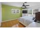 Bright bedroom featuring wood floors, a ceiling fan, and a built-in TV unit at 1309 Nokomis S Ave, Venice, FL 34285