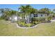 Nicely landscaped front yard with mature palm trees and a green lawn at 1309 Nokomis S Ave, Venice, FL 34285