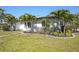 Well-maintained home with decorative shrubs and palm trees in the front yard at 1309 Nokomis S Ave, Venice, FL 34285