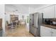 Open floor plan with kitchen view featuring travertine flooring and stainless steel refrigerator at 1309 Nokomis S Ave, Venice, FL 34285