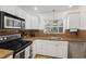 Bright kitchen showcasing granite countertops and stainless steel appliances at 1309 Nokomis S Ave, Venice, FL 34285