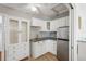 Efficient kitchenette with white cabinetry, stainless steel refrigerator, and sleek countertops at 1309 Nokomis S Ave, Venice, FL 34285