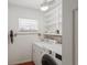 Laundry room features modern appliances, convenient shelving, and a bright window for natural light at 1309 Nokomis S Ave, Venice, FL 34285