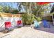 Outdoor seating area with colorful chairs, lush plants, and a privacy fence at 1309 Nokomis S Ave, Venice, FL 34285