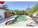 Inviting kidney-shaped pool with a brick surround, accented by tropical landscaping and a privacy fence at 1309 Nokomis S Ave, Venice, FL 34285
