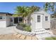 Backyard shed with pavers, brickwork, small palm tree, landscaping, and an easy access door at 1309 Nokomis S Ave, Venice, FL 34285