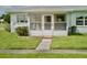 Well-maintained single-story home featuring a welcoming screened porch and a lush front yard at 5006 Springwood N Ave # 119, Pinellas Park, FL 33782