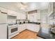 Bright kitchen features white appliances, cabinets, granite countertops and tile flooring at 5006 Springwood N Ave # 119, Pinellas Park, FL 33782
