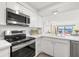 Bright kitchen with stainless steel appliances and views of the water and living area at 6265 Sun Blvd # 101, St Petersburg, FL 33715