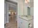 Half bathroom with granite countertop, sink, and access to the open floor plan of the home at 8044 Lago Mist Way, Wesley Chapel, FL 33545
