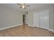 Neutral bedroom with wood-look flooring, closet, ceiling fan, and entry to hallway at 8044 Lago Mist Way, Wesley Chapel, FL 33545