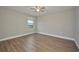 Bedroom featuring hardwood flooring, a ceiling fan, and natural light from a window at 8044 Lago Mist Way, Wesley Chapel, FL 33545