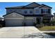 Two-story home featuring a three-car garage and manicured lawn at 8044 Lago Mist Way, Wesley Chapel, FL 33545