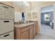 Bathroom vanity with granite countertop and double sinks, open to an adjoining bedroom at 1115 Andrew Aviles Cir, Tampa, FL 33619