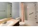 Bathroom featuring a shower with peach shower curtain, toilet, and sink with vanity at 1275 Drew St, Clearwater, FL 33755