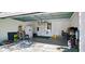 Spacious garage featuring a white refrigerator, a ladder, and a utility door at 1275 Drew St, Clearwater, FL 33755