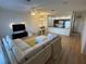 Open-concept living area features a plush sectional sofa, adjacent kitchen and light wood flooring at 1275 Drew St, Clearwater, FL 33755