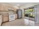 Kitchen with tile flooring, white appliances, stainless steel refrigerator, and sliding glass door to the patio at 1308 Costa Mesa Dr, Wesley Chapel, FL 33543