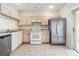 A view of the kitchen featuring white appliances, tile flooring, and a stainless steel refrigerator at 1308 Costa Mesa Dr, Wesley Chapel, FL 33543