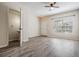 Open-concept living room with wood-look floors, ceiling fan, and plenty of natural light at 1308 Costa Mesa Dr, Wesley Chapel, FL 33543