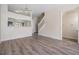 Inviting living room with wood-look floors, open view to kitchen, and staircase access at 1308 Costa Mesa Dr, Wesley Chapel, FL 33543