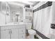 Bright bathroom featuring white cabinets, toilet, and shower with a black and white patterned shower curtain at 13215 Parkhurst Ct, Riverview, FL 33569