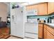 Bright kitchen with white appliances, wood cabinets, granite countertops and tile flooring at 13215 Parkhurst Ct, Riverview, FL 33569