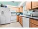 Kitchen with white appliances, wood cabinets, granite countertops and tile flooring at 13215 Parkhurst Ct, Riverview, FL 33569